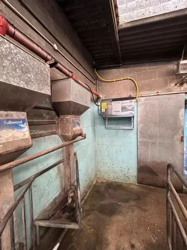 Dairy bay with the wall-mounted pressure washer installed at a raised height for safety at a farm in Atherstone